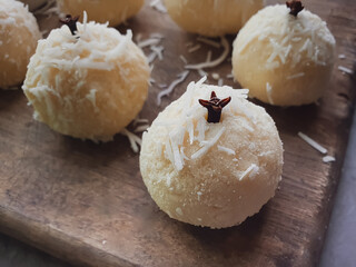 coconut kiss, typical Brazilian party sweets and cloves on a wooden background