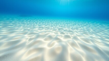 Underwater scene of sunlit white sand ocean floor with gentle waves creating a tranquil and serene underwater seascape.