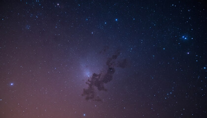 Obraz premium This breathtaking night sky displays an array of stars and dark cosmic clouds. The scene reveals the beauty of the universe during a clear evening