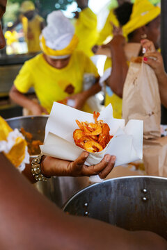 Acaraj&eacute; with vatap&aacute; and shrimp being served by a female hand at a typical Brazilian street stall