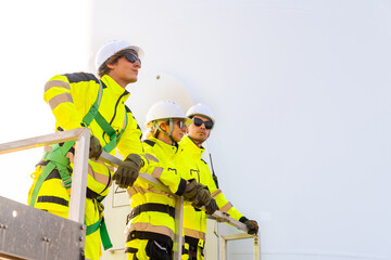 Wind turbine farm station engineer, green energy engineering, eco-friendly electricity power technology industry. Technician and engineer teamwork working maintenance repairing wind turbine generator.