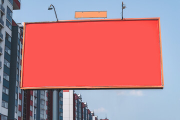 Red blank billboard mockup. Against the background of a new building of a multi-storey building....