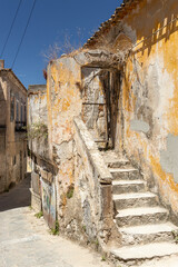 stone chairs at an abandoned house in an alley in Gythio, Greece