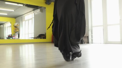 Woman enjoys energetic dance workout session in brightly lit gym setting embracing body movement fitness motivation and healthy living goals. Close up of feet.