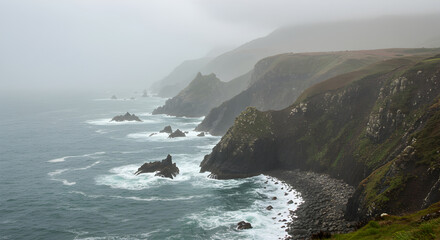Dramatic Coastal Cliffs And Crashing Waves Under An Overcast Sky