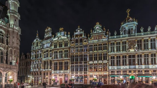 Night hyperlapse of the illuminated Grand Place Guilds facade in Brussels, Belgium. Historic art guild associations in Baroque architecture timelapse, with people walking on the UNESCO-listed square