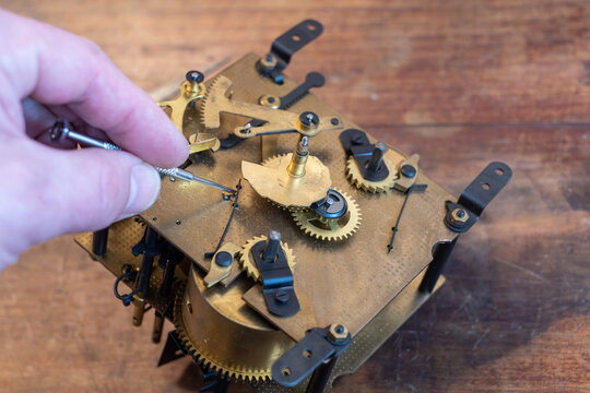 The mechanism of the wall clock.Repair of mechanical watches with gears.Vintage mechanism maintenance service