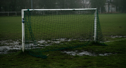 Fototapeta premium Empty Soccer Goal on Muddy Field During a Rainy Day In Nature