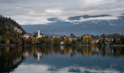 Fototapeta premium Assumption of mary pilgrimage church on lake bled, surrounded by mountains and colorful autumn foliage, Slovenia