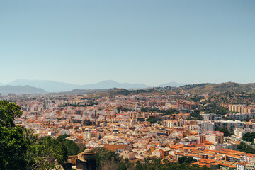 Fototapeta premium Scenic cityscape with mountains, capturing vibrant urban life and natural beauty.