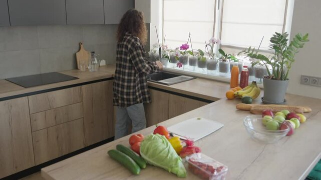 Washing Hands In Kitchen Sink Before Cooking With Fresh Groceries Nearby