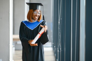 happy african american female student with diploma at graduation