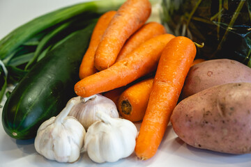 Closeup of fresh seasonal vegetables: potatoes, carrots, garlics, cucumbers