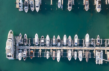 Top view of a luxury yacht and boats along the Miami marina. Aerial shot of a white yacht in...
