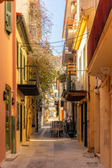 narrow colorful alley with flowers and balconies in old town of Nafplio, Greece