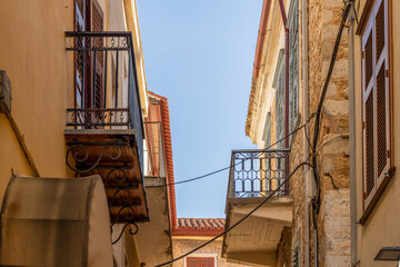narrow colorful alley with balconies in old town of Nafplio, Greece