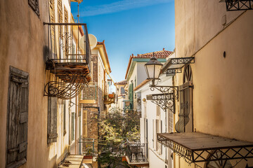 narrow colorful alley with flowers and balconies in old town of Nafplio, Greece