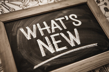 Wooden framed chalkboard with "What's New" written in chalk, showcasing announcements or updates, ideal for blogs, websites, or social media
