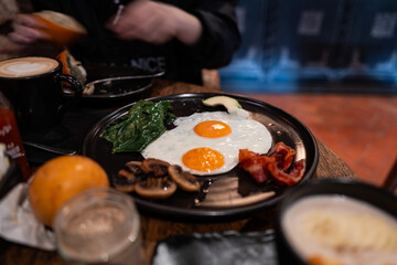 Two sunny-side-up eggs sizzling in a black frying pan