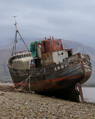 The Corpach Shipwreck in Scotland – abandoned rusty boat on a rocky shore