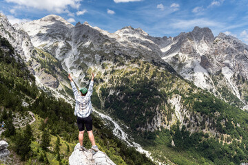 A hiker girl with a backpack in the mountains of Albania. Trekking in the Prokletie Mountains.