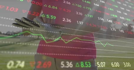 Mature female golfer adjusting white golf glove on fairway, showing stock market data overlays - Powered by Adobe