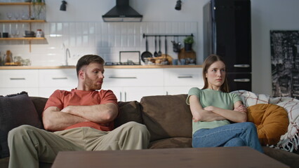 Unhappy couple quarrel sitting home couch showing disagreement. Marriage crisis