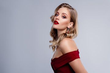 Lady celebrity in red cocktail dress looking on copyspace grey color background