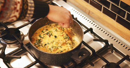 Hands, pot and cooking in home, soup and heat with ingredients, nutrition and food on stove in...