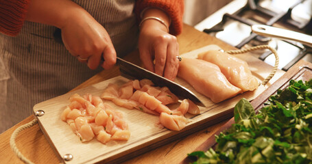 Hands, chicken and cutting board in kitchen, home and meal prep with knife, poultry and cooking healthy food. Person, chef and tools for organic meat, nutrition and diet for wellness at apartment
