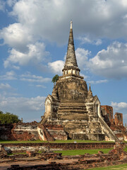 Fototapeta premium People visiting the famous Wat Maha That Buddhist temple landmark, peaceful sacred place of worship with ancient construction. Historical Thai heritage and culture, brick monument.