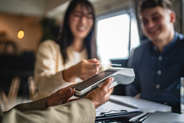 japanese woman entrepreneur paying bill contactless with debit card