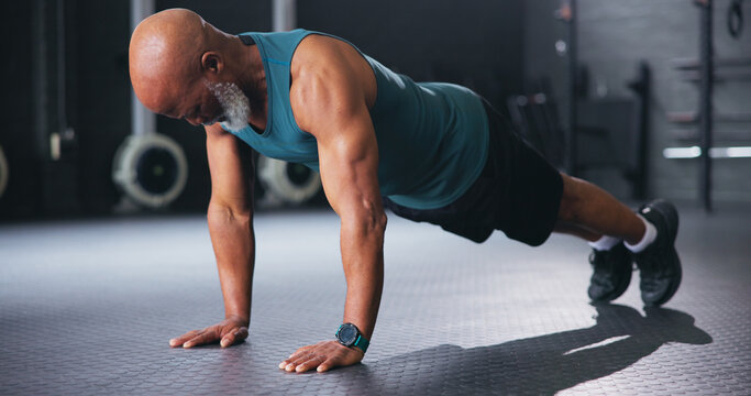 Push ups, fitness and senior man in gym, training and body workout with core strength. Pensioner, health club and elderly person in wellness center, exercise and retirement with energy and routine