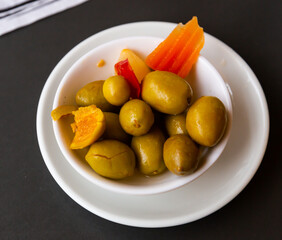 Plate of pickled olives with a stone with the addition of carrots.