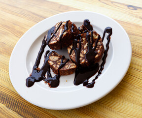 Served chocolate rolled cake with walnut on plate in restaurant ..