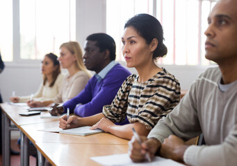Portrait of interested korean woman on lesson in school auditorium. Adult learning and education concept