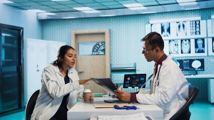 Specialist and patient discussing diagnostic results in a modern medical office, establishing...