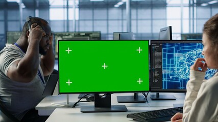 Employee working on green screen computer in server hub, using AI to process data. IT developer at...