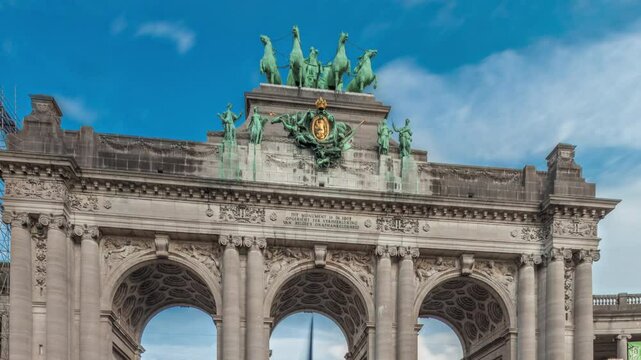 Hyperlapse of the Cinquantenaire Arcade in Jubelpark, Brussels, Belgium. The memorial triumphal arch stands tall under dramatic clouds timelapse, symbolizing Belgian history and independence.