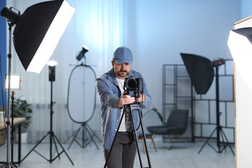 Man with professional video camera in studio