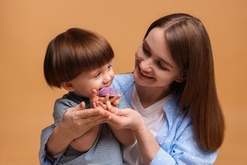 Mother and baby eating tasty mochi on brown background