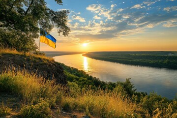 Scenic view of a wide river under a colorful sunset sky with a Ukrainian flag waving from a high bank.