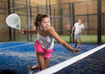 Athletic woman with passion plays padel
