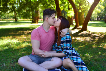 Young Romantic Couple Kissing Outdoors in Sunny Park