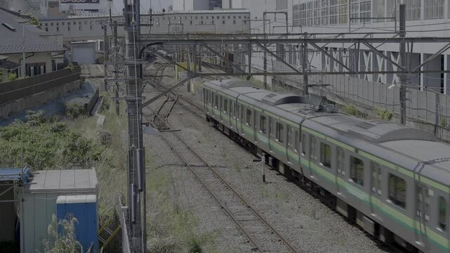 横浜線の町田駅へ高速で進入し、八王子方面へ向かうE233系の快速電車