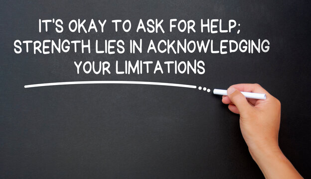 It is okay to ask for help, strength lies in acknowledging your limitations text written on black board. Inspirational and motivational concept.
