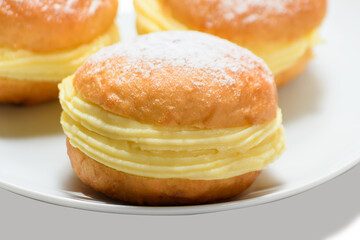 Delicious bakery dreams with creamy filling and powdered sugar on a white plate