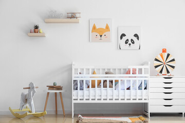 Interior of light children's bedroom with crib and animal paintings
