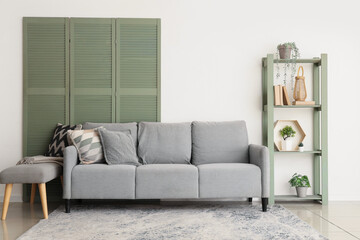 Interior of living room with sofa, soft bench and shelf unit