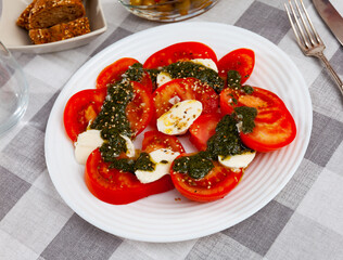 Fresh italian caprese salad with mozzarella and tomatoes on white plate
